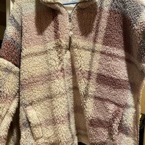 Faux Sherpa 1/2 zipper jacket with pockets. Colors are creams, mauves and grey